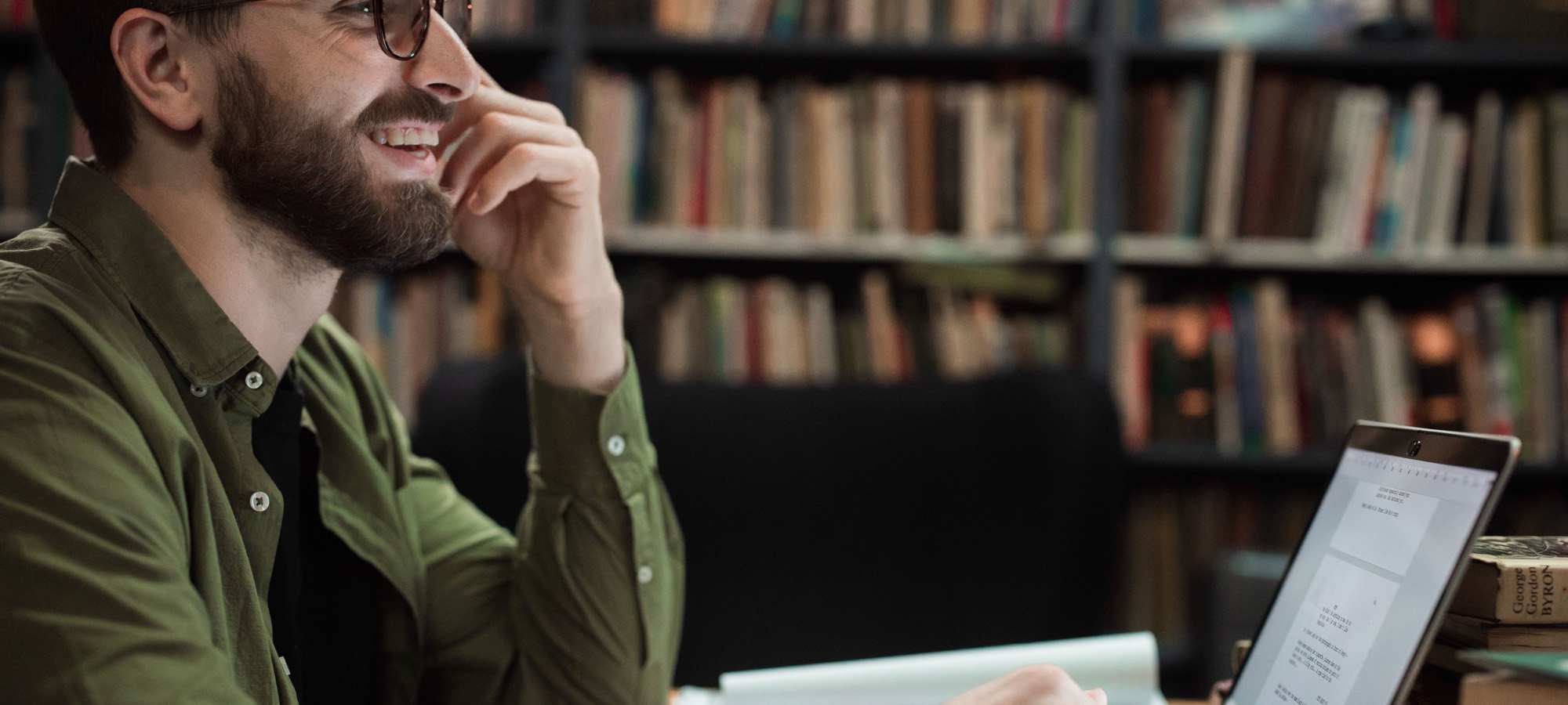 A student at a laptop in a library, talking through a station.